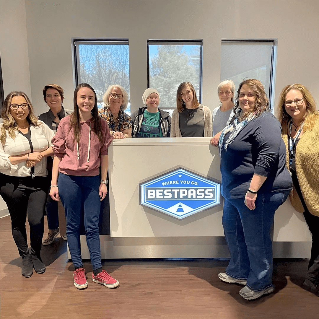 group of women employees standing around Bestpass sign