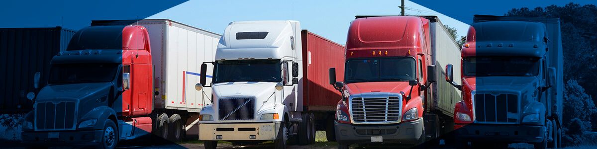 Red and white tractor trailer trucks parked in a row